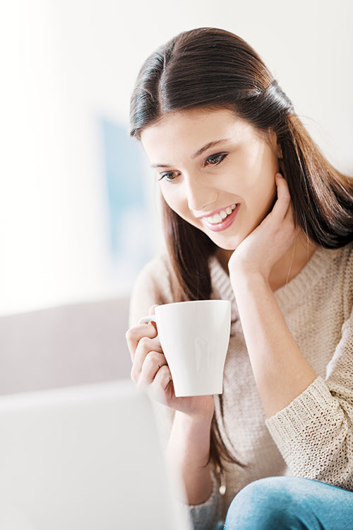 Woman reading her laptop with coffee cup